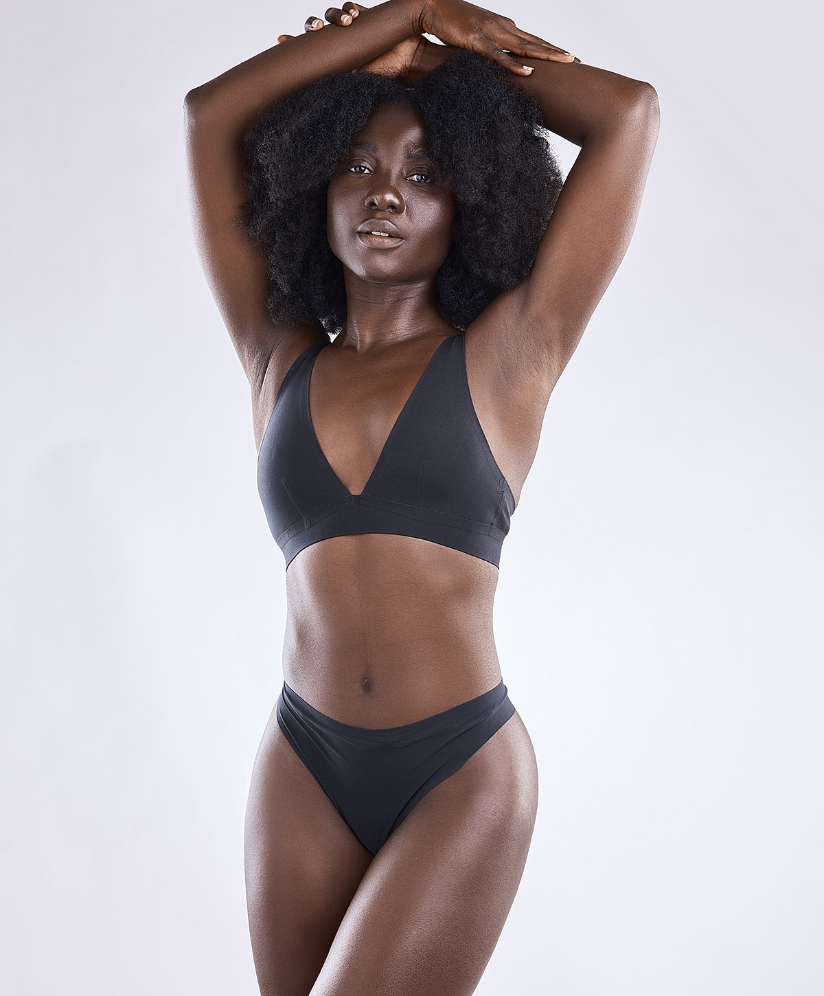 Model in black swimwear posing confidently.