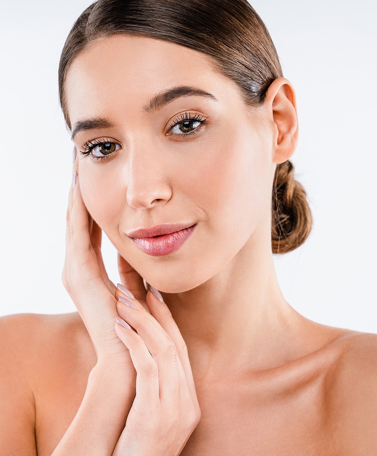 Woman with natural makeup, touching her face.
