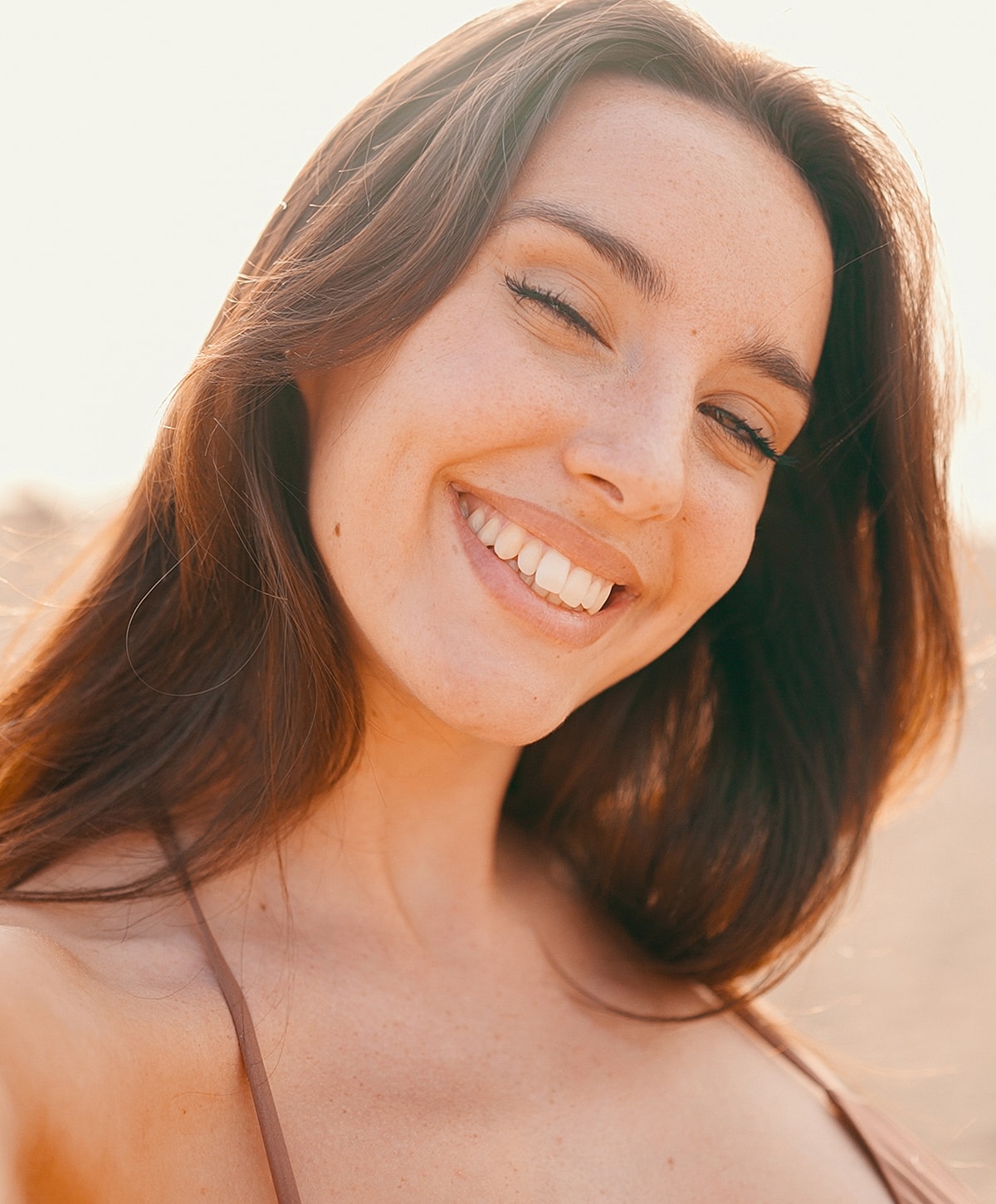 Smiling woman with long hair outdoors.