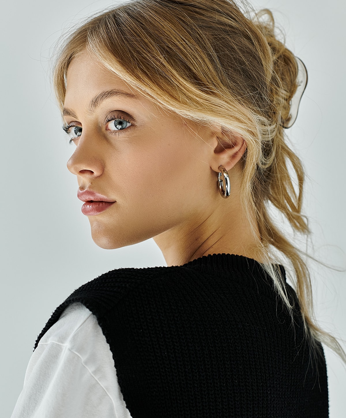 Smiling woman with long hair against a wall.
