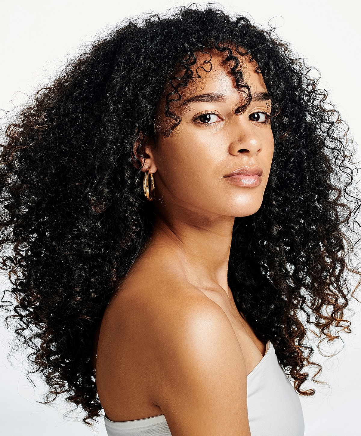 Woman with curly hair and hoop earrings.
