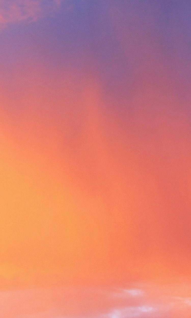 Vibrant pastel sunset sky with soft clouds.